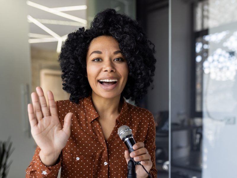 Businesswoman speaking into microphone with enthusiasm