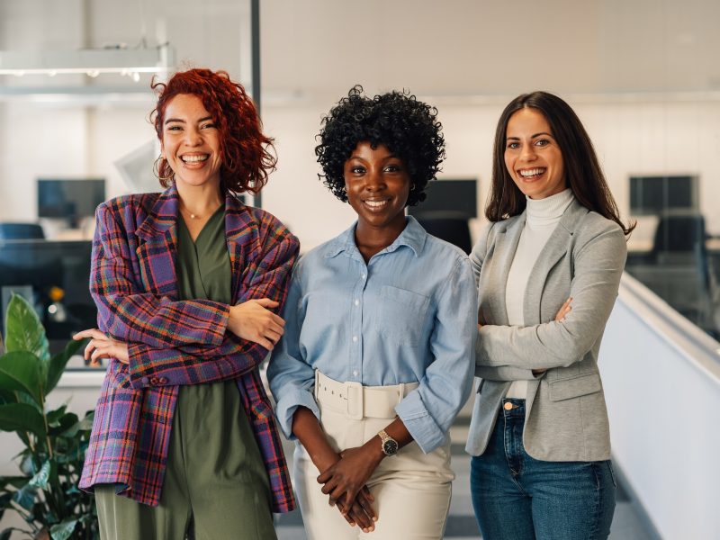 Multiracial women posing in the office while looking into the camera
