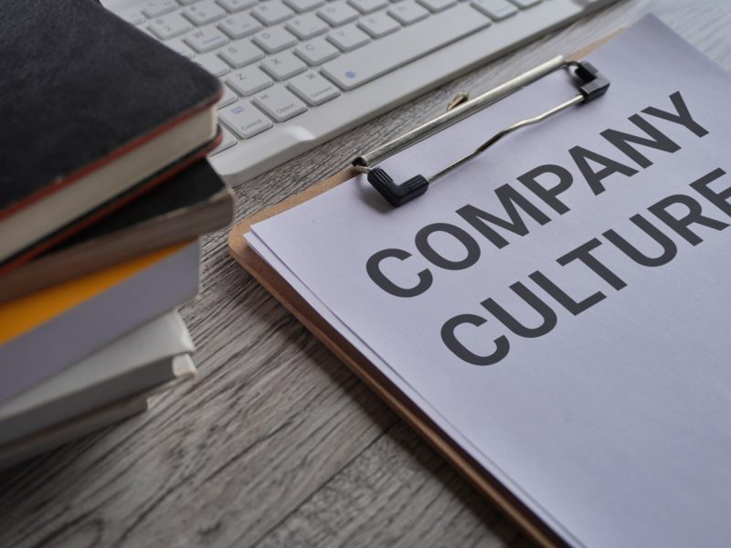 Paper clipboard with text COMPANY CULTURE on office desk