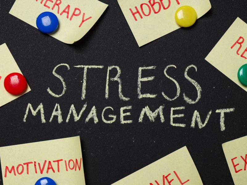 Text Stress management and paper on black background