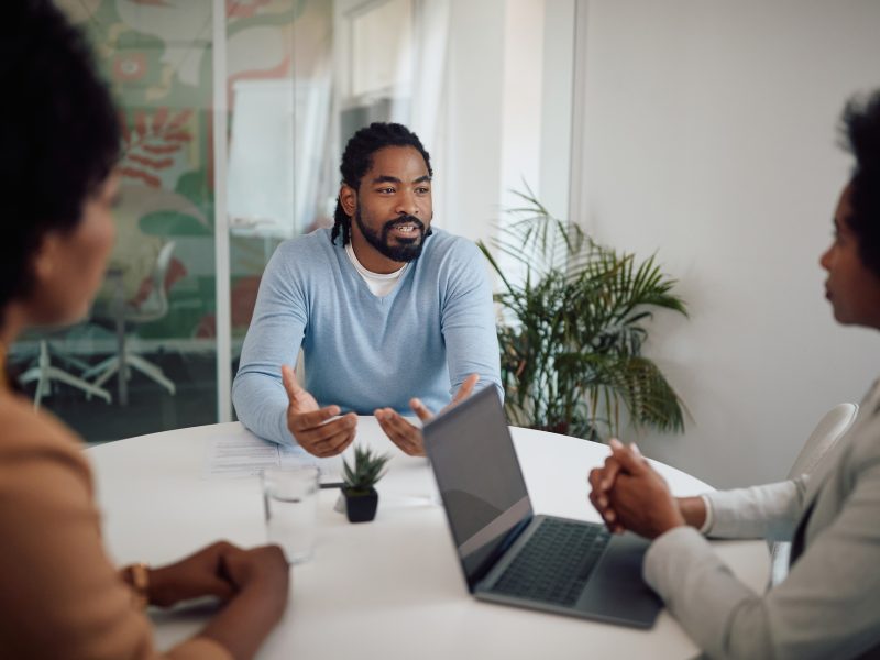 Young black man talking to human resource team during job interview in the office.